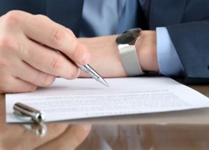 Man holding Pen Reading a Legal Document