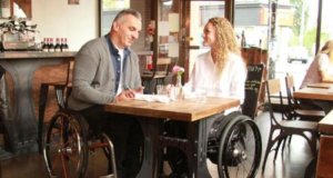 A man and women in wheelchairs at a coffee table