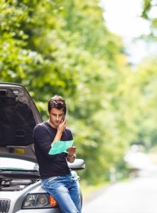 Man leaning on a car with the hood up