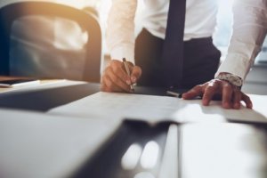 Man signing papers on desk