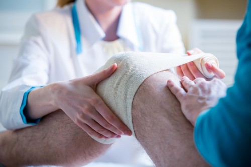 doctor taping up knee