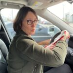 Laura Hillyer behind the wheel with a "smartwatch"