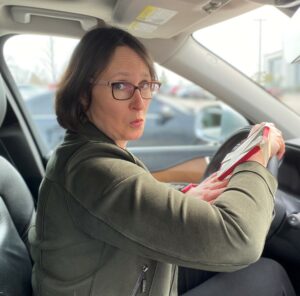 Laura Hillyer behind the wheel with a "smartwatch"